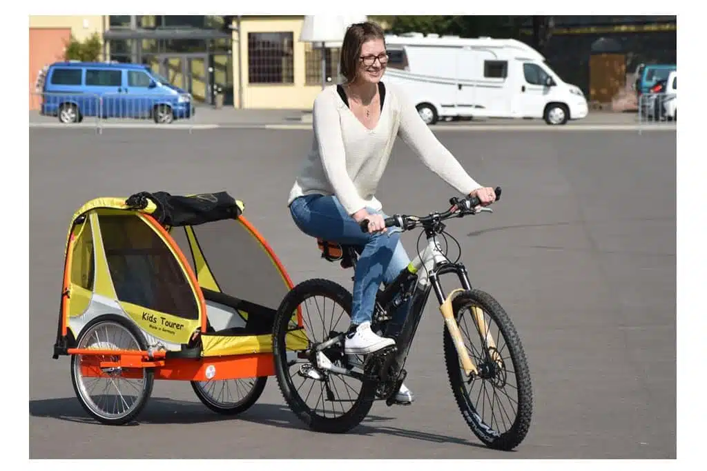 Im Fahrradanhänger von Kids Touring fährt der Nachwuchs sicher und bequem auch auf längeren Touren mit. Exklsuiv: Der Anhänger wird komplett in Deutschland produziert.