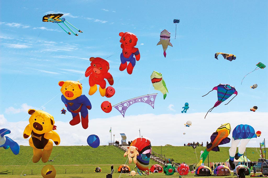 Viele bunte Drachen steigen am Himmel auf