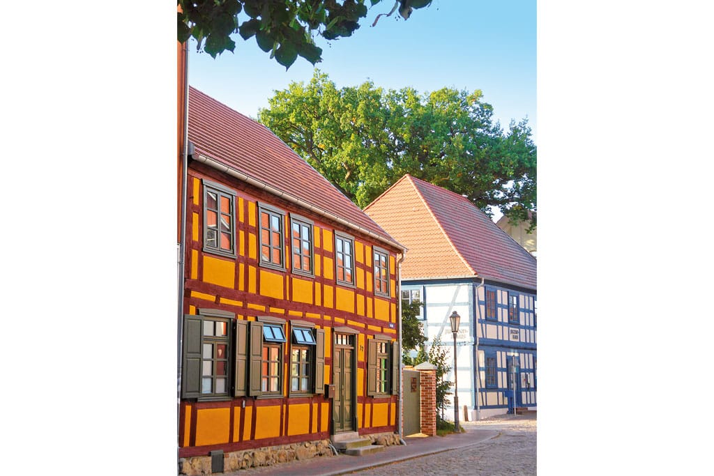 Zwei bunte Fachwerkhäuser mit roten Dächern