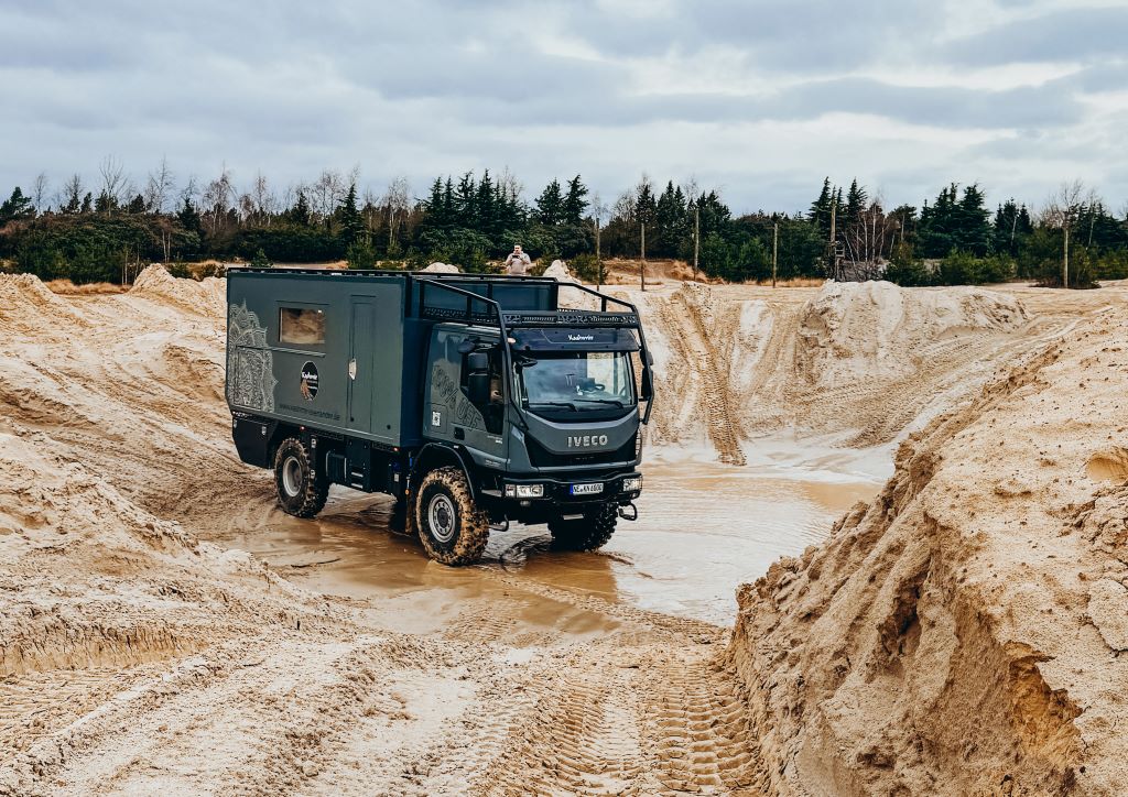 Schwarzer Expeditionstruck in schlammiger Grube