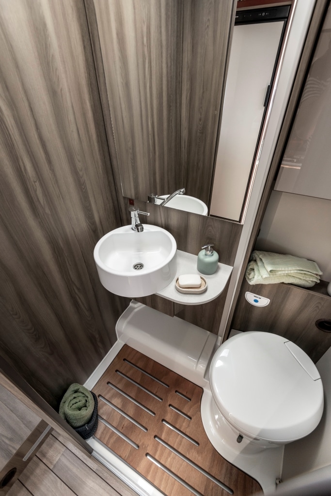 Kleines Bad mit Toilette und rundem Waschbecken im Wohnmobil