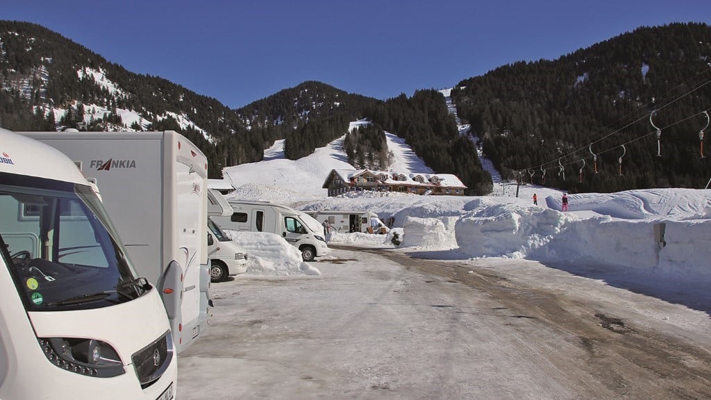 Stellplätze in der Nähe von Skiliften: Campingfahrzeuge auf einem Campingplatz im Schnee