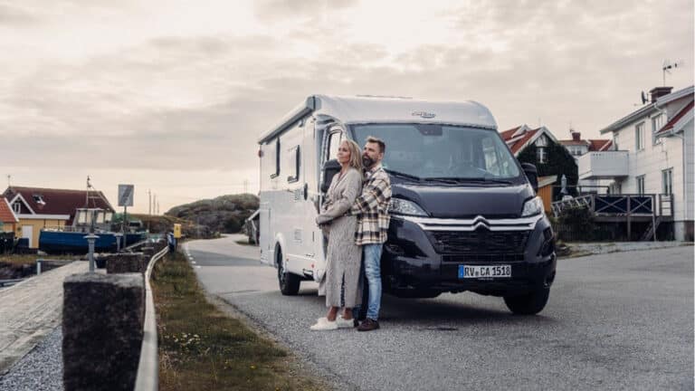 Ein Paar steht eng umschlungen vor einem Wohnmobil
