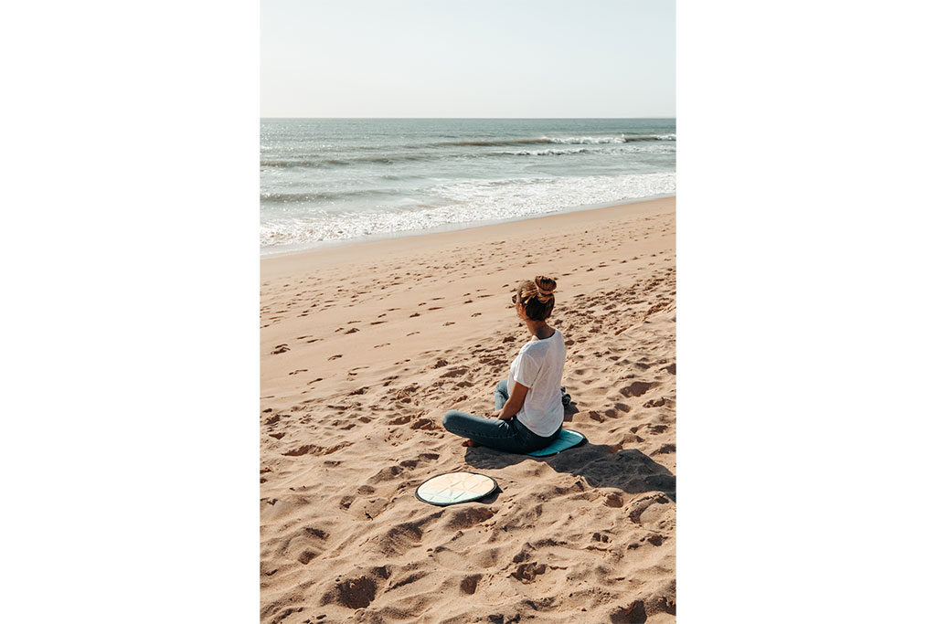 Wassersport-Zubehör: Frau mit Sitzkissen am Strand