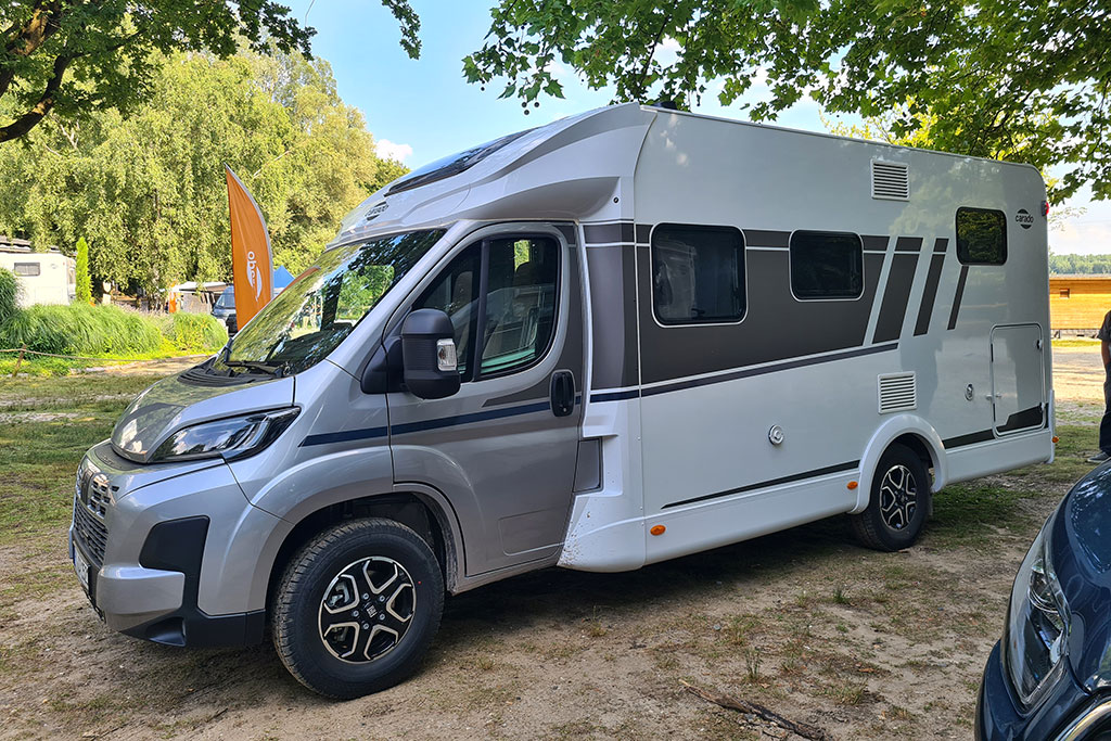 Außenansicht der Fahrerseite eines grau-weißen Wohnmobils