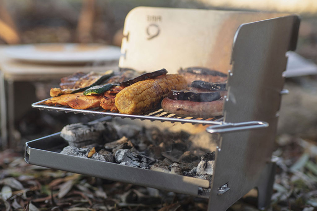 Gemüse und Fleisch auf kleinem Edelstahlgrill