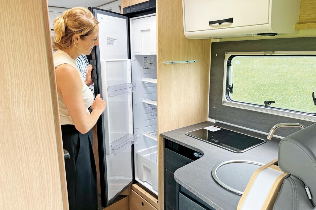 Redakteurin öffnet den Kühlschrank im Wohnmobil