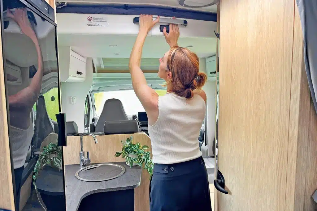 Redakteurin zieht ein Hubbett im Wohnmobil von der Decke herunter.