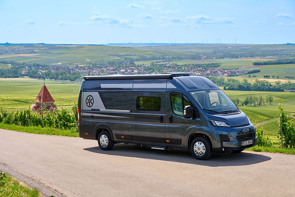 Dunkelgrauer Campervan auf einer Landstraße