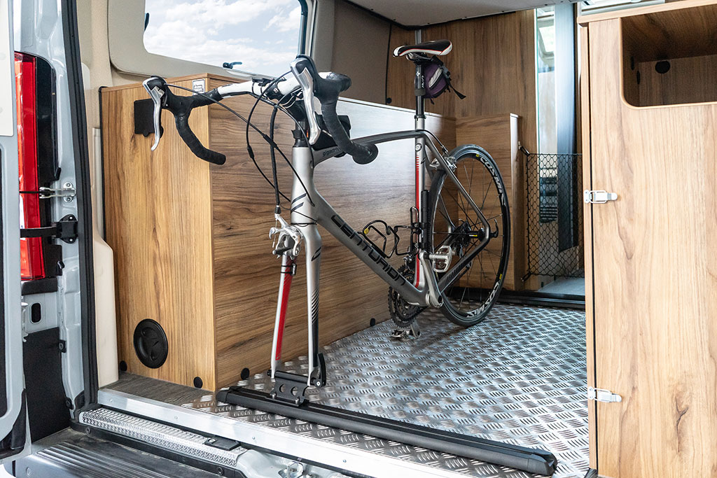 Fahrrad befestigt in der Heckgarage im Campervan