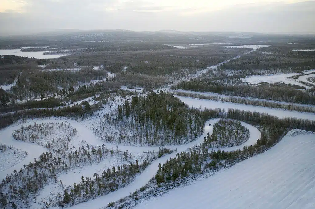 Winterreifentest 2025: Winterlandschaft mit kurviger Teststrecke und verschneiten Wäldern aus der Luft fotografiert.