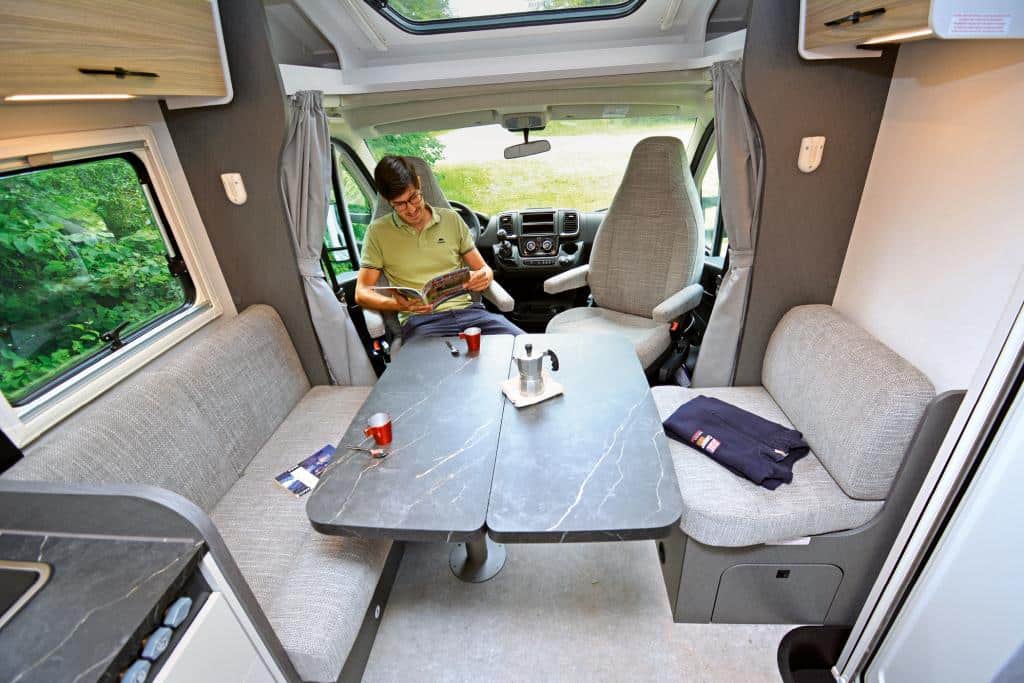 Redakteur sitzt an der Sitzgruppe im Wohnmobil