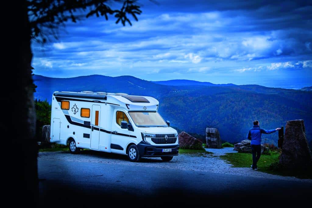 Wohnmobil in bergiger Landschaft in der Abenddämmerung
