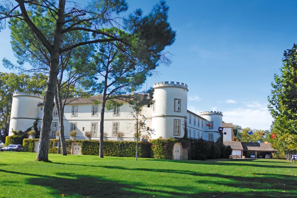 Schlossartiges Gebäude auf eienr gepfelgten Rasenfläche