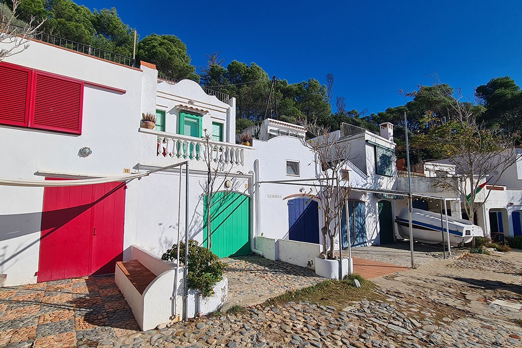 Weiße Hüschen mit bunten Türen an steinigem Strand