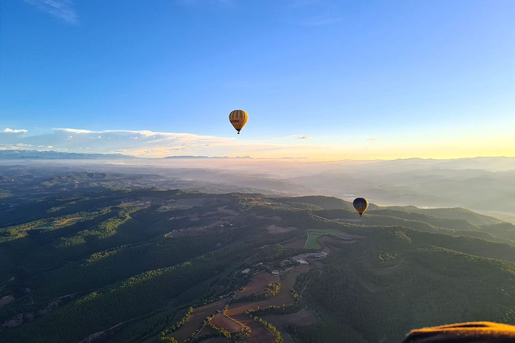 Zwei Heißluftballons über weiter Berglandschaft
