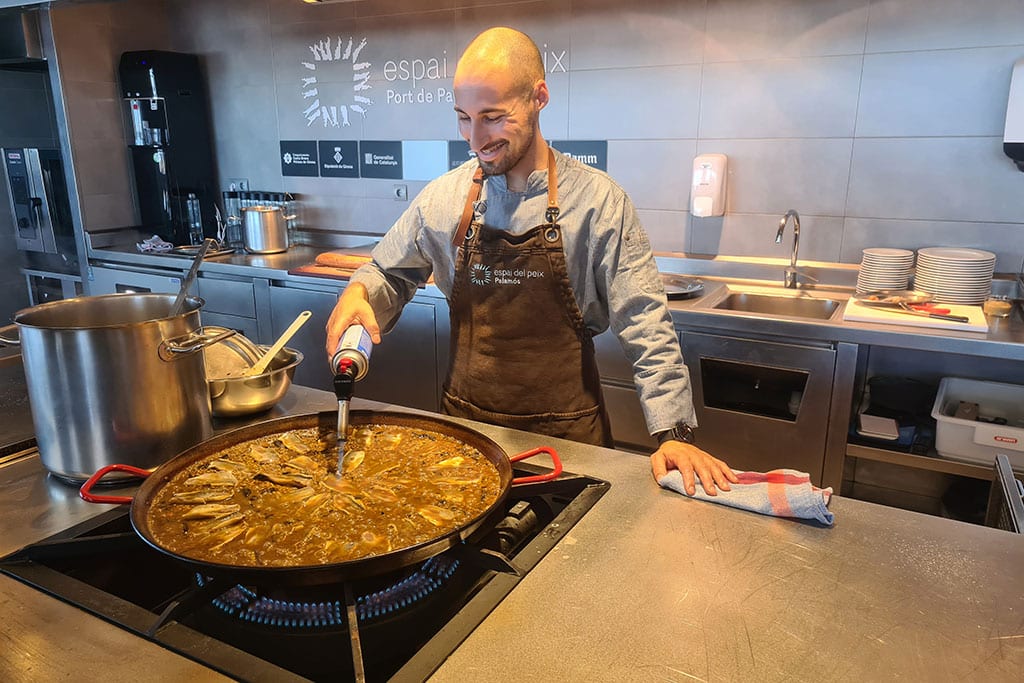 Ein Koch bereitet eine katalanische Paella zu